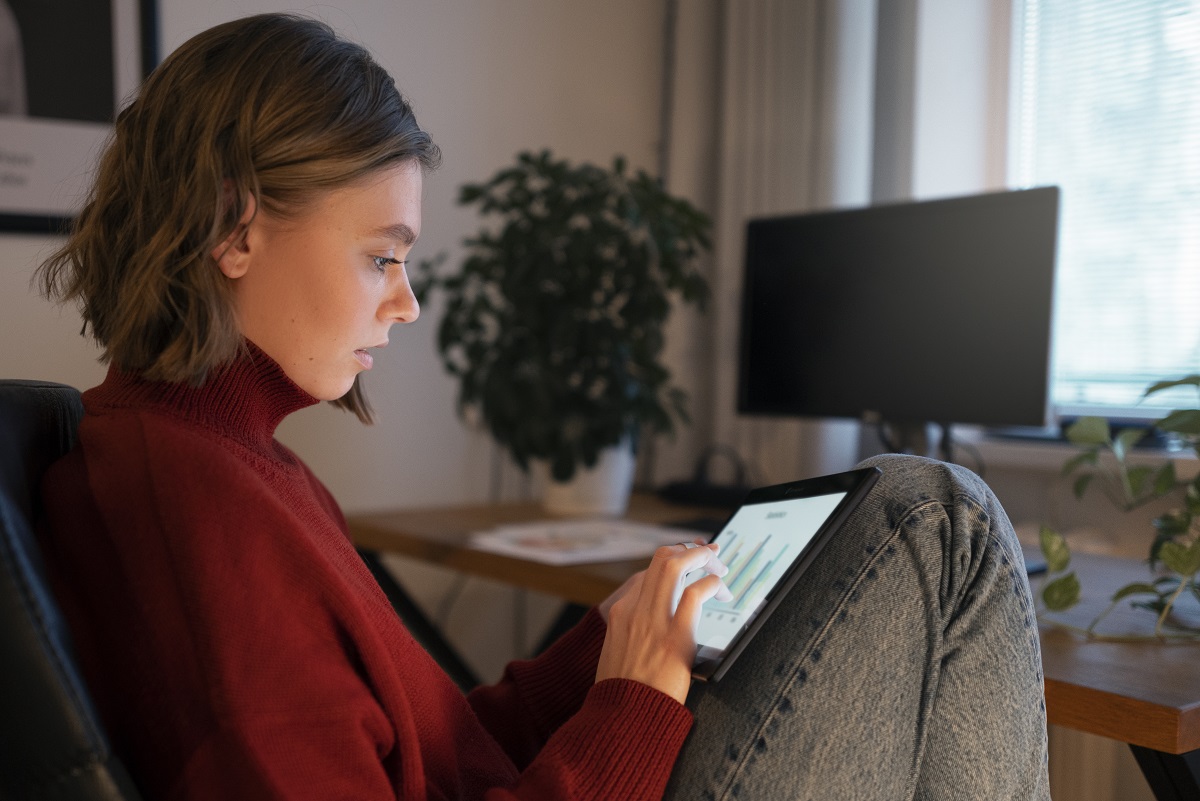 Mulher sentada em sofá utilizando plataforma para consulta online